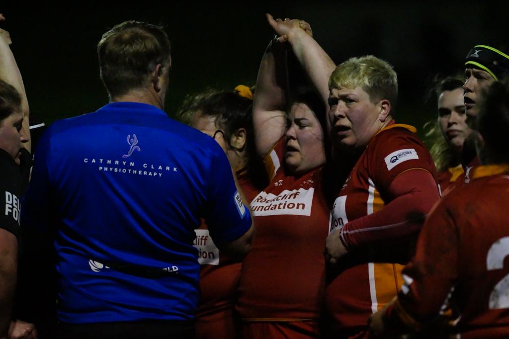rugby scrum with referee wearing sponsored shirt